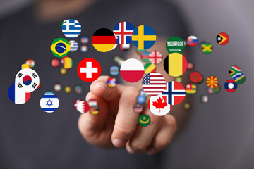 A hand pointing towards a selection of international flags, representing globalism, connection and...