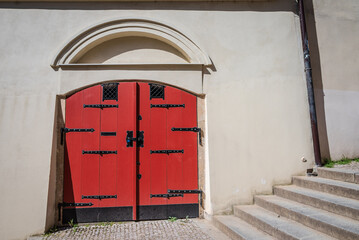 Medieval-style red wooden and iron door on the side of an old building in Prague Old Town, Czech...