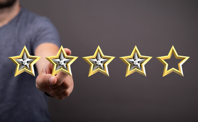A person's hand points at four gold stars, symbolizing a positive rating or review. Concept of success and quality service. Perfect for business