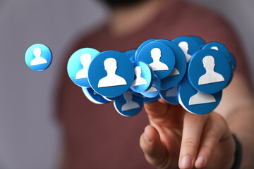 A hand touches floating user profile icons representing digital connection and community in social media. Perfect for illustrating networking an