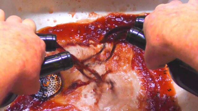 A man pours 4 bottles of spoiled waste red wine to the sink