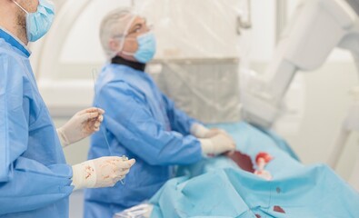 Surgeons in blue scrubs and masks perform a vital procedure involving advanced microsphere technology aimed at treating liver tumors, ensuring blood flow restoration and targeted therapy