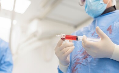 A medical professional prepares a syringe filled with red fluid in a sterile environment, symbolizing advancements in targeted cancer therapies for liver tumors