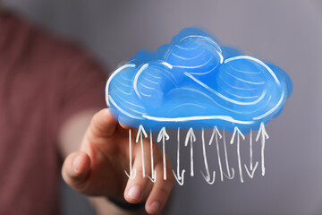 Close-up of a hand touching a cloud with arrows, a concept of the cloud, data, or weather on a digital interface