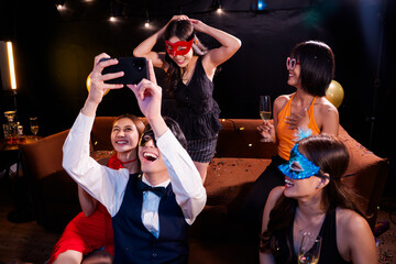 Beautiful woman having fun with group of friends clinking champagne glasses during celebration party. Drink concept.