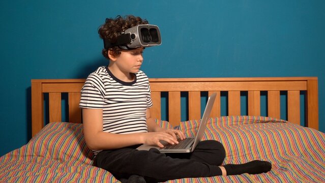 Little boy Immersed in cyberspace, metaverse, learning in virtual reality. Kid playing games. Child learning using virtual reality headset. Education child in virtual reality glasses. laptop and globe - Powered by Adobe