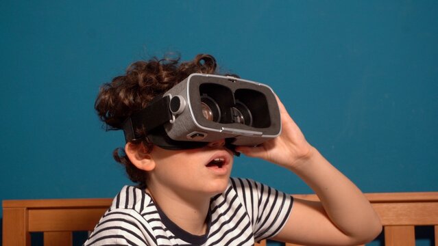 Little boy Immersed in cyberspace, metaverse, learning in virtual reality. Kid playing games. Child learning using virtual reality headset. Education child in virtual reality glasses. laptop and globe - Powered by Adobe