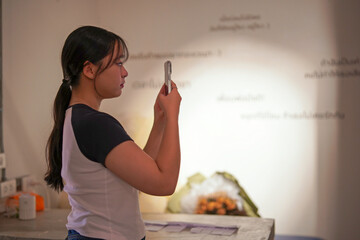 Portrait of young girl holds a smartphone in her hand and looks forward in the room.