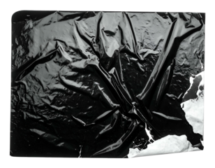 Glossy, crinkled black surface with tear, revealing white