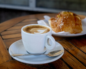White coffee cup with a spoon on a wooden table