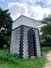 Stone Arch Pavilion with Textured Wall under Cloudy Sky