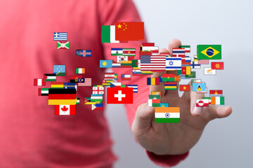 A hand touching flags representing different countries, symbolizing global communication, travel,...