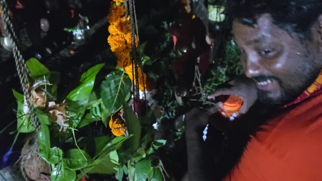 Authentic footage of Kanwariya devotees performing a traditional nighttime puja before collecting holy water during the Kanwar Yatra pilgrimage in India. The ritual includes offerings, prayer