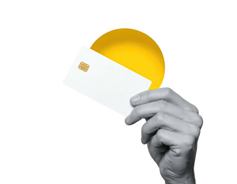 A grayscale hand holds a white credit card with a yellow circle behind it