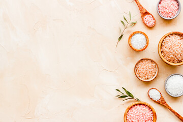 Fototapeta na wymiar Beauty spa therapy cosmetics and wellness flat lay - sea salt in many bowls with flowers, top view