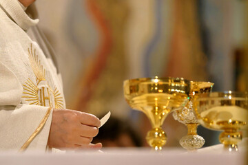 Holy Host in the hands of a priest during the celebration of Holy Mass in a Catholic church