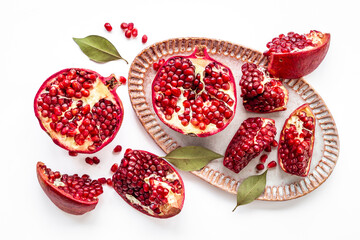 Top view of fresh ripe pomegranate and pieces on plate for eating, top view.