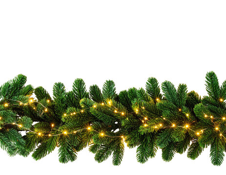 Christmas garland of pine branches with tiny yellow string lights against a black background