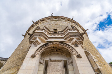 Fototapeta premium Round medieval tower built in stone and decorated with gargoyles seen from its bottom