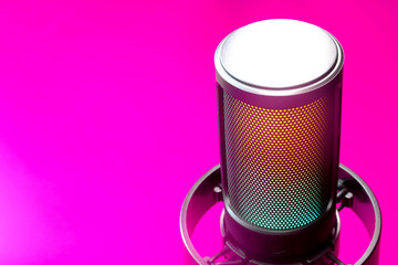 Pro condenser microphone with RGB LED glow on a neon magenta backdrop; club disco vibe for concert, DJ, podcast or live stream, with wide copy space for headline. Photo