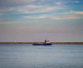 Mall tugboat sailing near a calm harbour