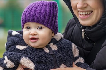 Cute baby in warm clothes smiling outdoors