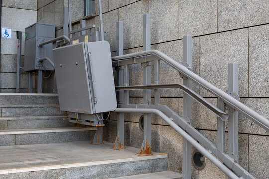 Elevator lift for people with disabilities at building stairs. Emphasizes accessibility with metallic design and functionality to ensure inclusivity in public spaces. Creating accessible environment - Powered by Adobe