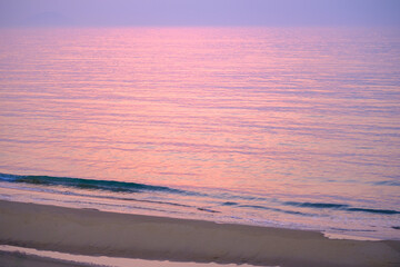 Gentle shoreline under a purple and pink evening sky