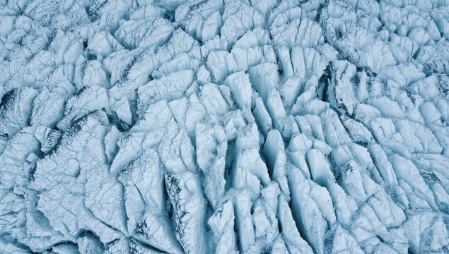 Fototapeta Aerial close-up of icy glacier surface showcasing abstract patterns and natural textures in a winter landscape