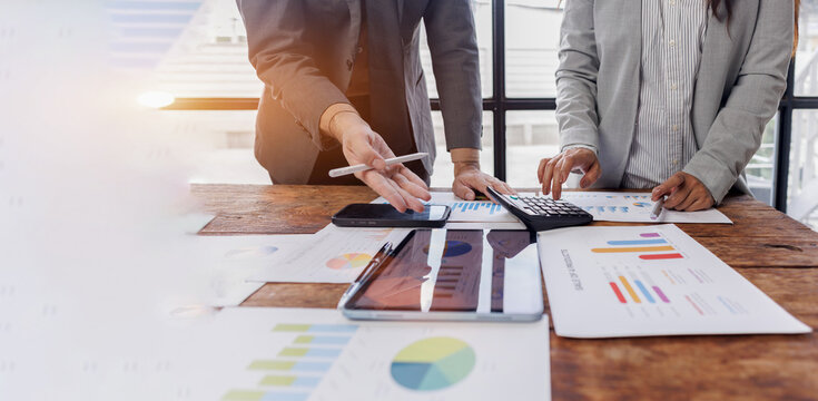 Business team working at office, using calculator to calculate company finance, accounting with laptop computer on table, budget management. Doing finance, budgeting and tax calculation
