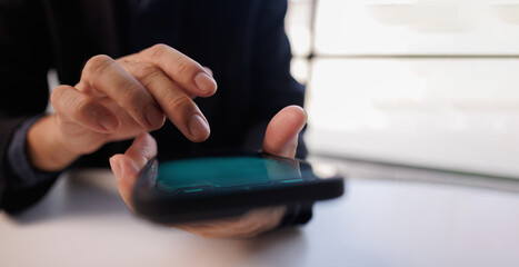Man using mobile phone with laptop computer on office table. Business woman surfing the internet, searching the information on smartphone working on laptop computer at workplace
