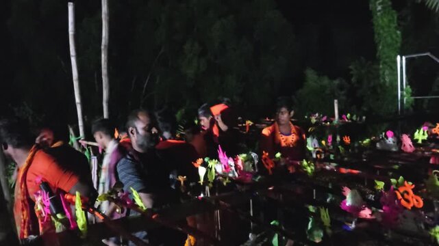 Authentic documentary footage of Kanwariya devotees gathering at a riverbank during the sacred Kanwar Yatra in India. Wearing traditional saffron clothing and carrying decorated Kanwars