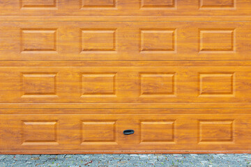 Modern wooden garage door with rectangular panel design. Surface with warm wood texture and natural grain. Ideal for backgrounds, architectural visuals, and construction design projects.