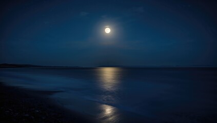 Bright full moon shining over cold ocean at night