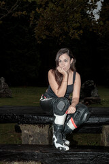 Woman motorcyclist in gear reflecting outdoors at night