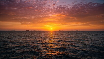 Vivid sunset illuminating the ocean with vessels in the distance