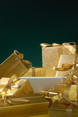 Vertical arrangement of stacked gold gifts with warm lighting. Ideal background for elegant festive...