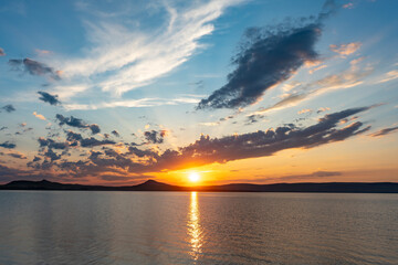 A colorful sunset over a lake among the clouds.