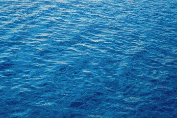 Obraz premium A peaceful scene of smooth blue water with subtle waves and mirrored reflections, evoking a sense of calm and renewal.