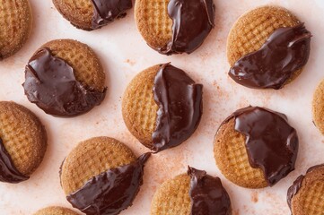 Cinnamon wafer biscuits coated in caramelized chocolate against a pale background