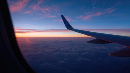 Fototapeta premium View from an airplane window showing the wing during sunset