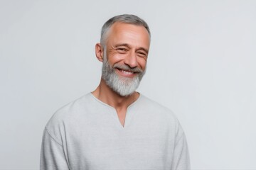 Obraz premium Mature caucasian male smiling in gray shirt against neutral background