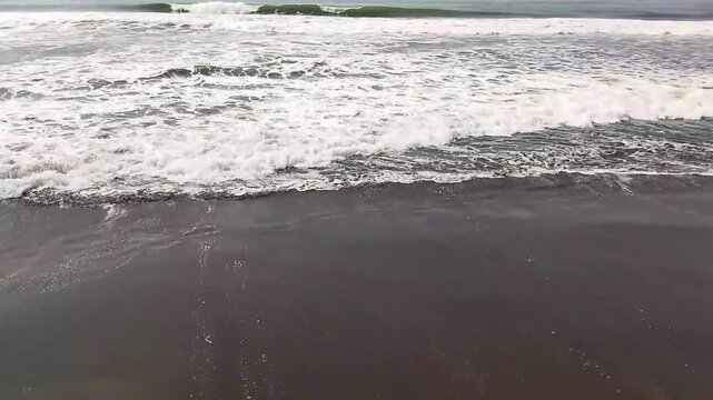 Wide Shot of Heavy Sea Waves and Cloudy Horizon at a Natural Indonesian Shoreline.

