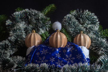 Yellow Christmas balls on a background of decorated Christmas tree branches. Low key.