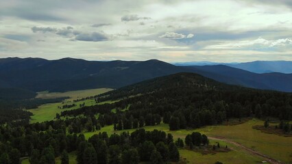 Aerial view of forested mountains and green valley. Media