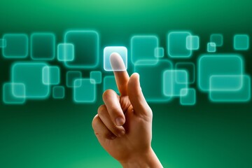 Hand touching a glowing button on a virtual interface with green background