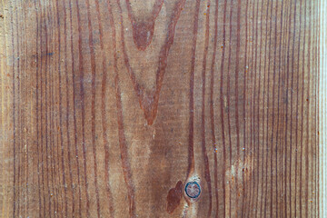 A detailed close-up shot of a natural rustic wooden board with a beautiful grain texture and a distinctive knot.