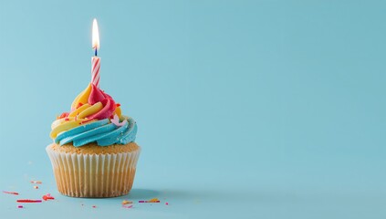 Cupcake topped with a lit candle on a blue backdrop with space for your message