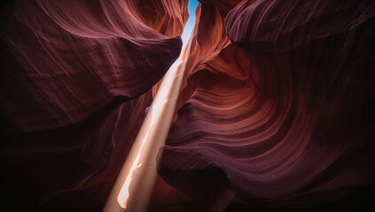 A ray of sunlight pierces through the narrow rock formations in a famous slot canyon