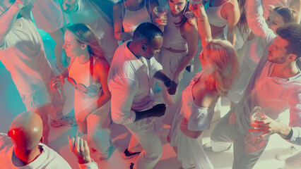 People dancing with glowing energy at elegant white party. Concept of lifestyle entertainment, expressive movement, visual branding for event culture and nightlife campaigns.